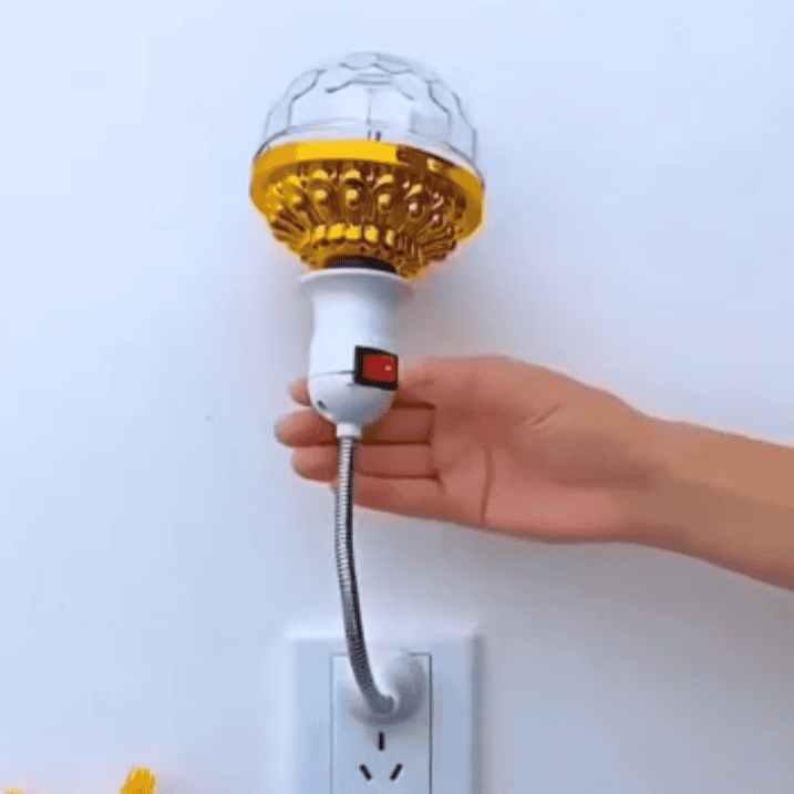 Hand plugging in LED rotating disco ball light with flexible neck into wall outlet
