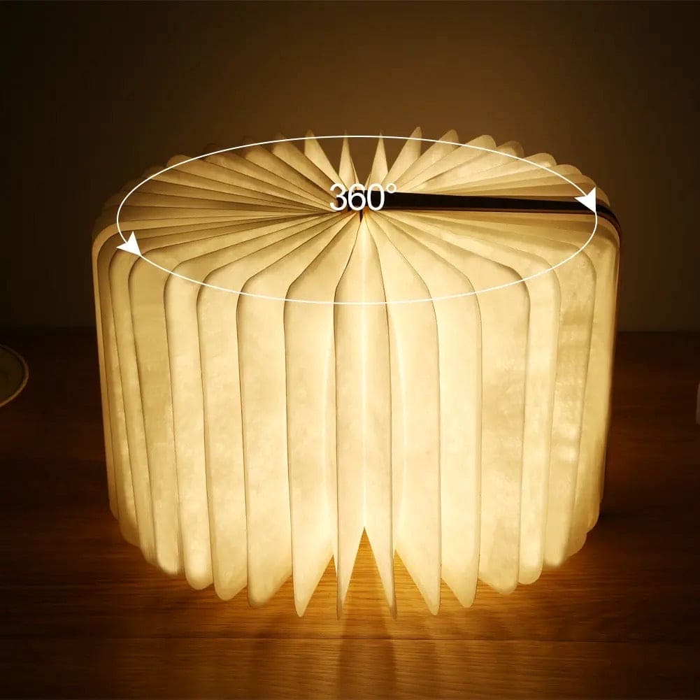 Round glowing LED wooden book lamp placed on wooden surface with 360 degree rotation feature