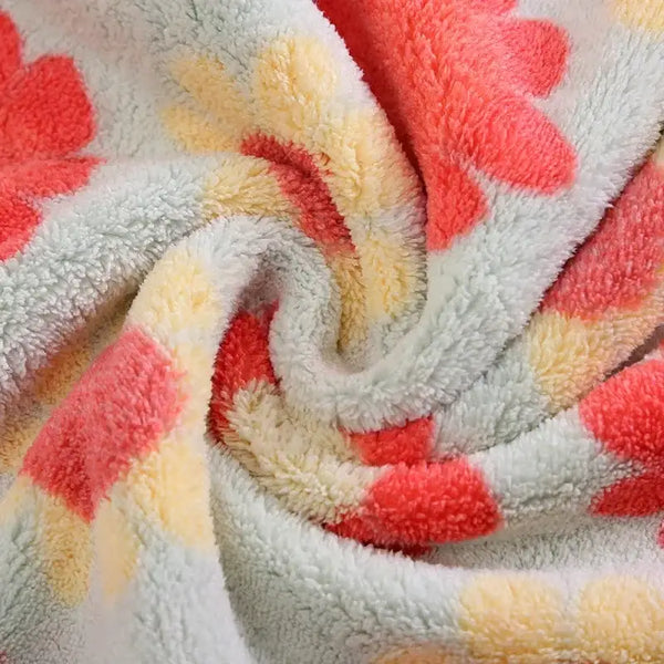 Close up of soft plush floral cotton face towels with coral and yellow flower pattern on light gray background