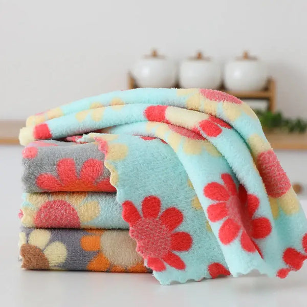 Stack of soft pastel floral cotton face towels with red and yellow daisy print for bathroom and travel