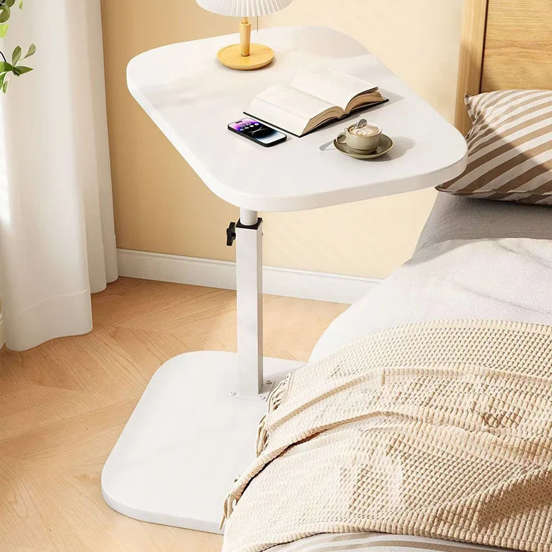White lifting side table for living room with adjustable height and smooth surface next to bed