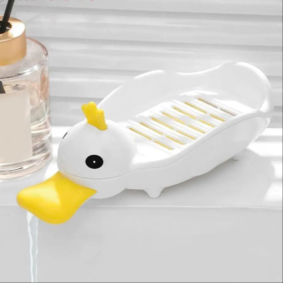 White and yellow cartoon duck soap dish with drainage slats holding a soap bar on a bathroom counter
