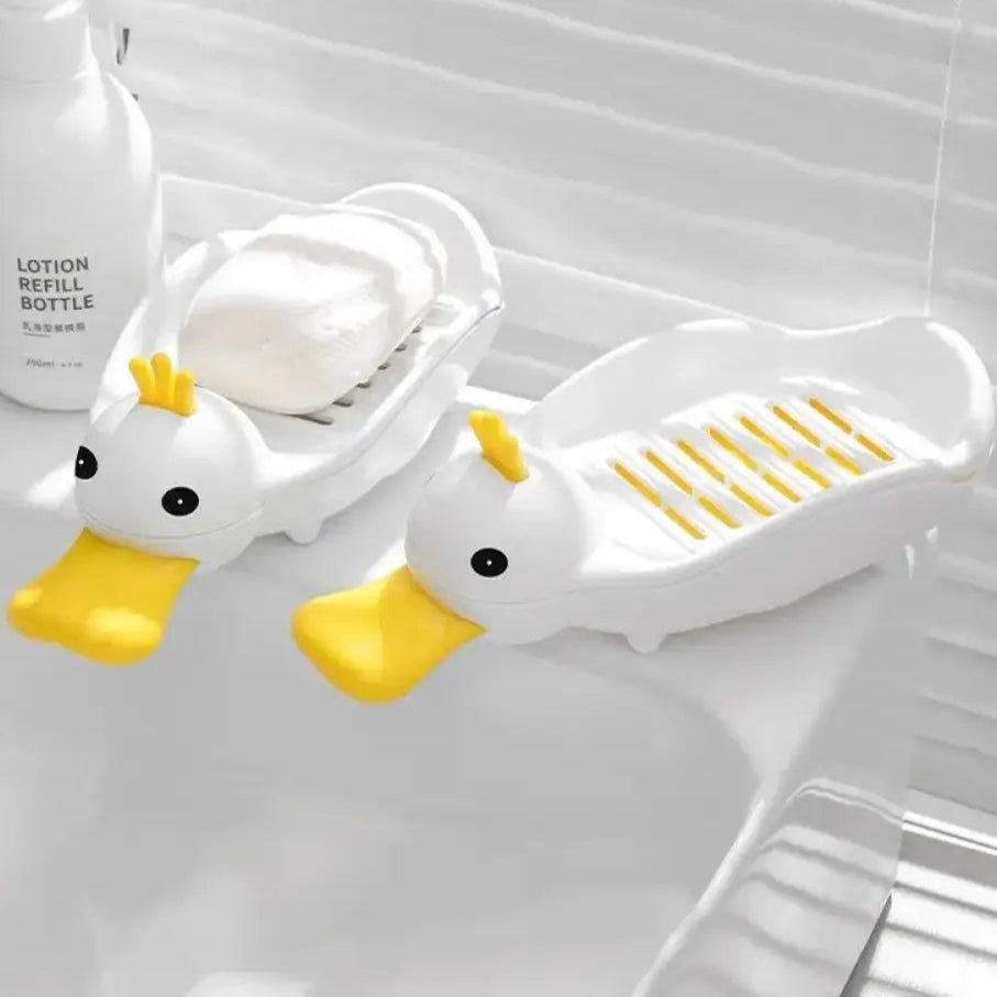 Cartoon duck soap dish in white and yellow holding soap, placed on bathroom sink by Clarify.pk