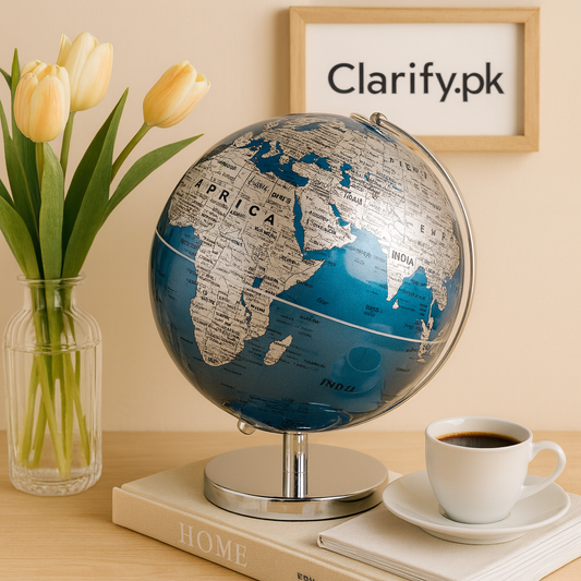 Luxury decorative world globe in blue and silver on a silver stand beside a coffee cup and flowers