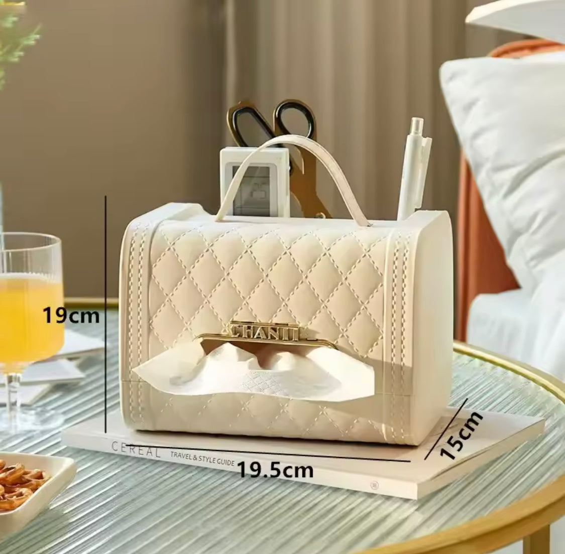 Elegant beige handbag tissue box holder with quilted design and gold-plated tissue dispenser on glass table