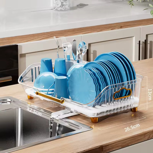 Luxury kitchen dish drainer with clear design and gold accents holding blue plates and utensils on wooden countertop