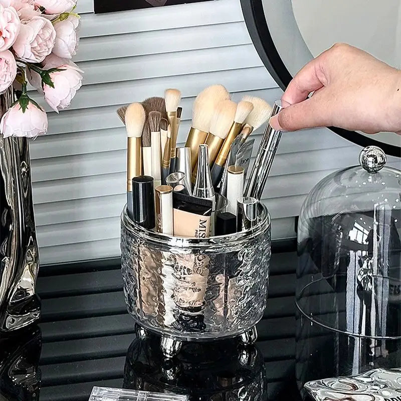 Luxury makeup brush organizer holding various makeup brushes and cosmetics on a black vanity table