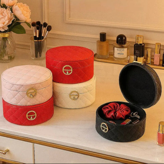 Luxury quilted jewelry storage box set in red, white, and black with gold accents on a vanity table