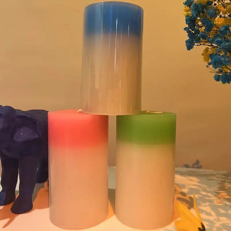 Set of three colorful magic wax mood candles in blue, red, and green gradient tones displayed on a table