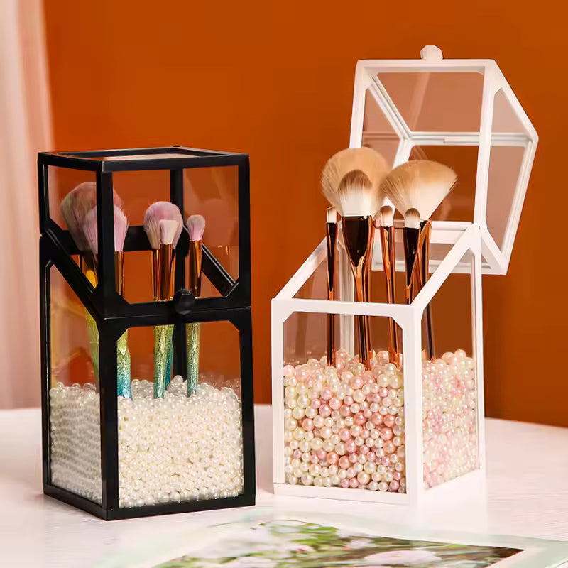 Black and white makeup brush storage box filled with decorative pearls holding various makeup brushes