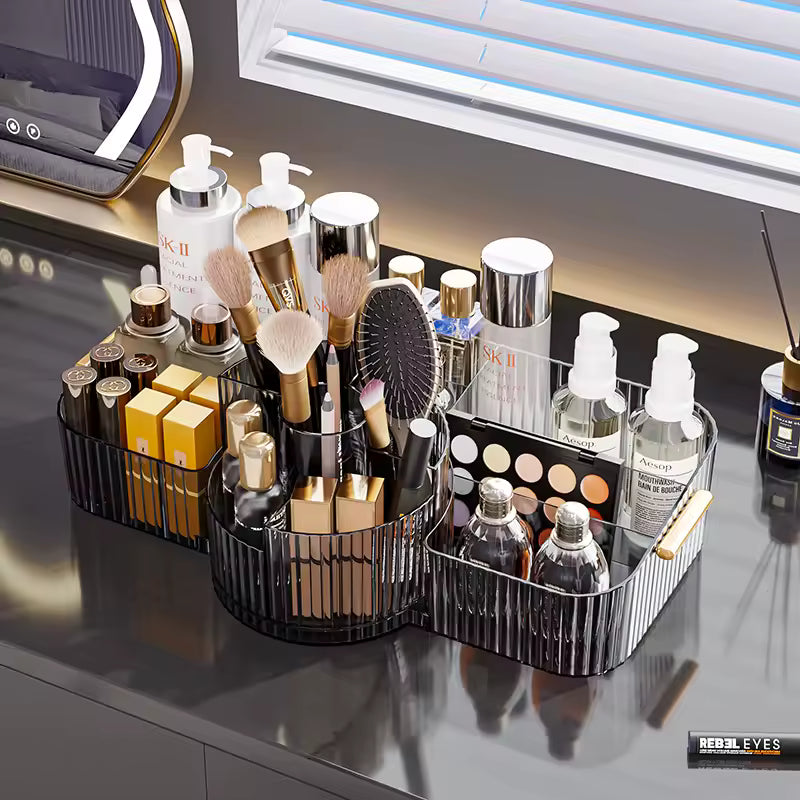 Black makeup organizer box for vanity with multiple compartments holding brushes, bottles, and cosmetics on a vanity table