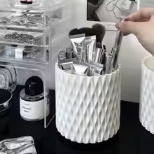 Clarify.pk brushes stored in a white container next to a makeup organizer storage box on a vanity table