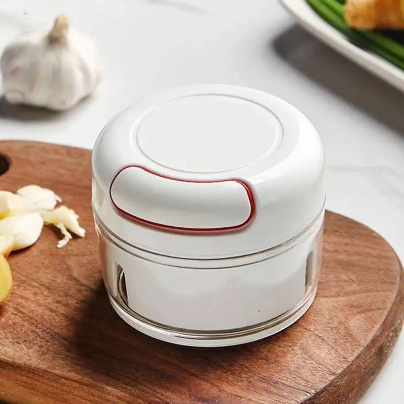 Compact manual garlic chopper with white top and clear container for easy garlic chopping