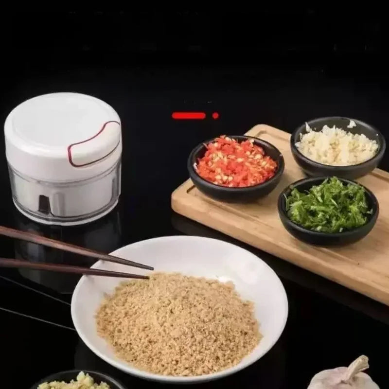 Manual garlic chopper with chopped garlic, herbs, and spices displayed on a wooden board and a white bowl