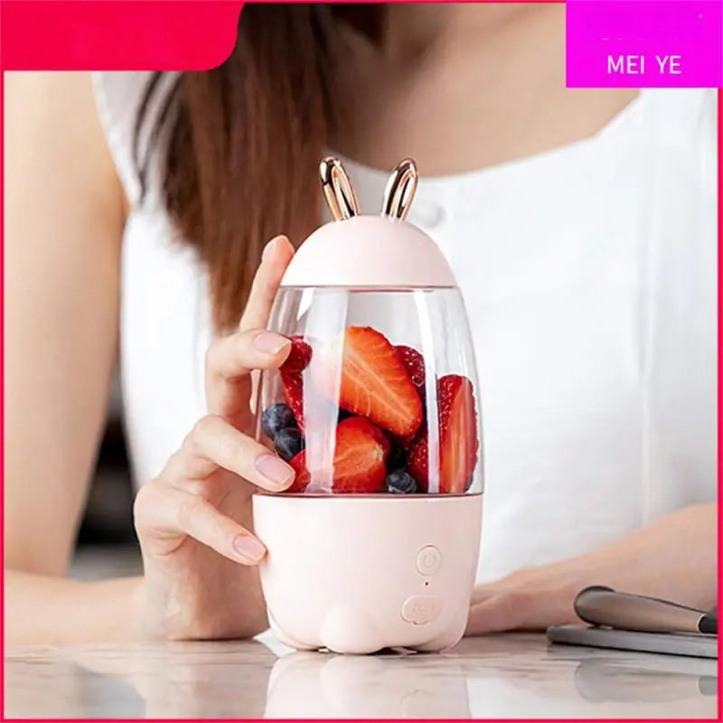 Portable electric juicer with cute bunny ears design blending fresh strawberries and berries