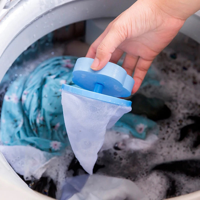 Hand placing mesh filter laundry bag for washing machine with blue top inside washing machine with clothes