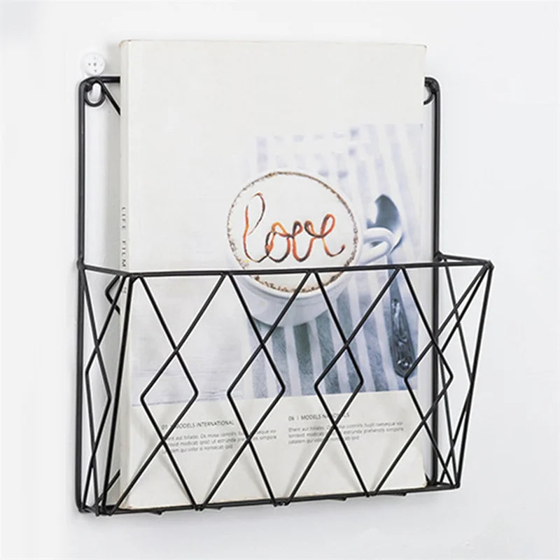 Black metal wall mounted rack with geometric design holding books or magazines on white wall