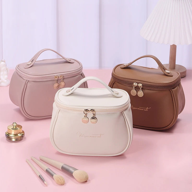 Set of three portable makeup case with zipper in white, brown, and pink with gold zipper and handle