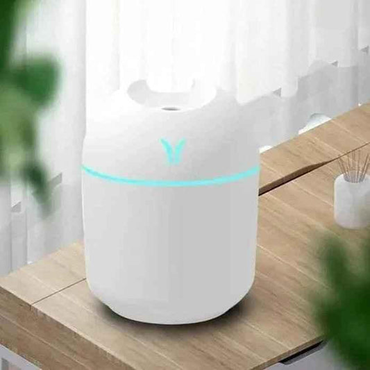 Clarify white mini air humidifier 250ml with glowing blue light on wooden table by window