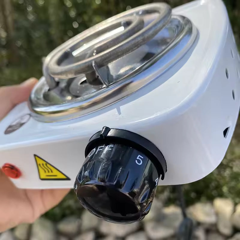 Clarify.pk mini electric stove white coal burner with temperature control knob held in hand