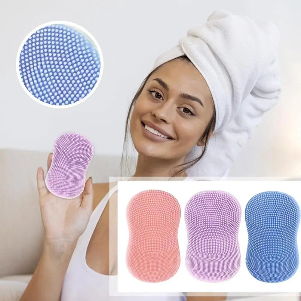 Mini facial cleansing brush silicone facial brush in pink purple and blue held by smiling woman with towel on head