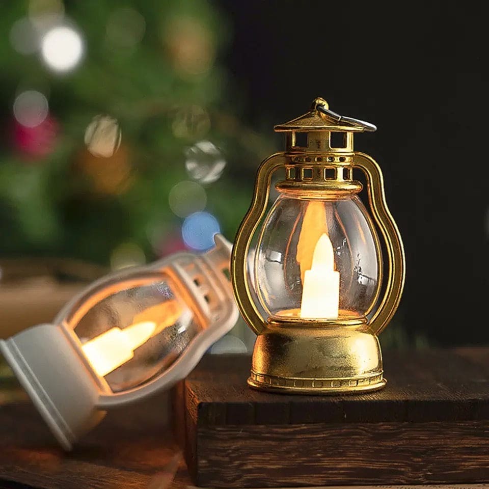 Gold and white mini lantern lamp for home decor with glowing candle light on wooden surface