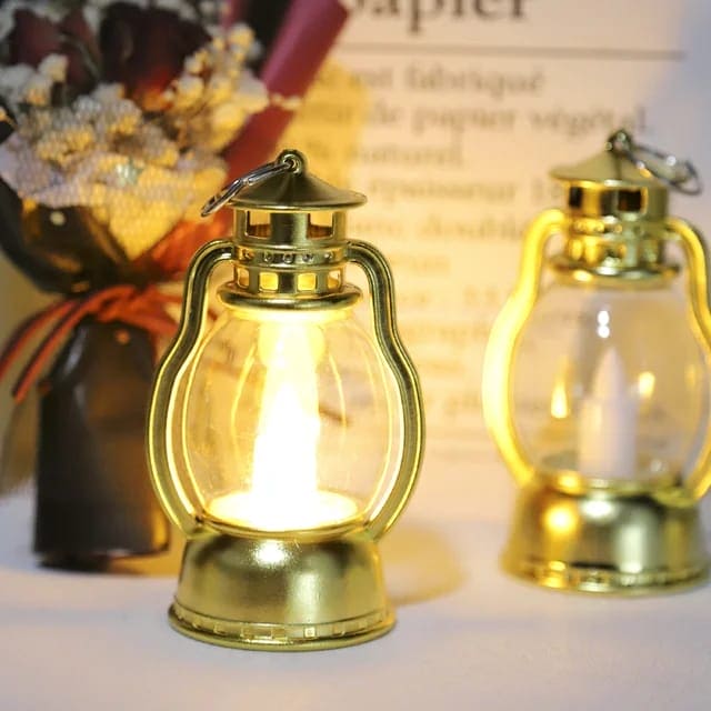 Gold mini lantern lamp for home decor glowing with warm light on a table with decorative flowers