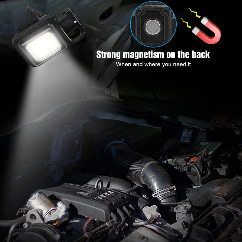 Mini LED flashlight keychain with strong magnet attached to car engine for hands-free lighting