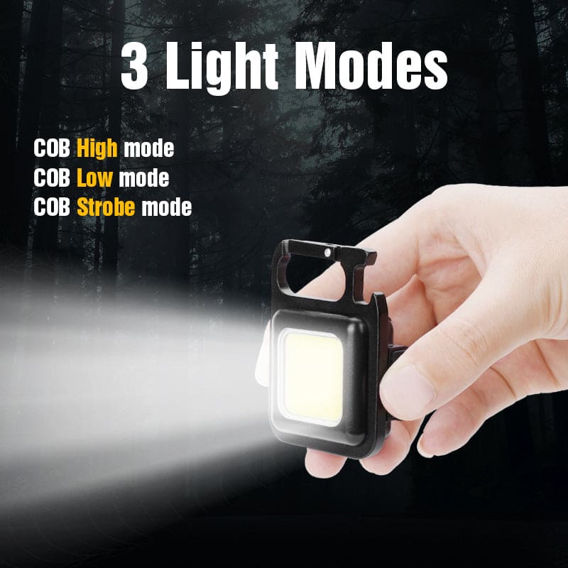 Hand holding mini LED flashlight keychain with three light modes including high low and strobe