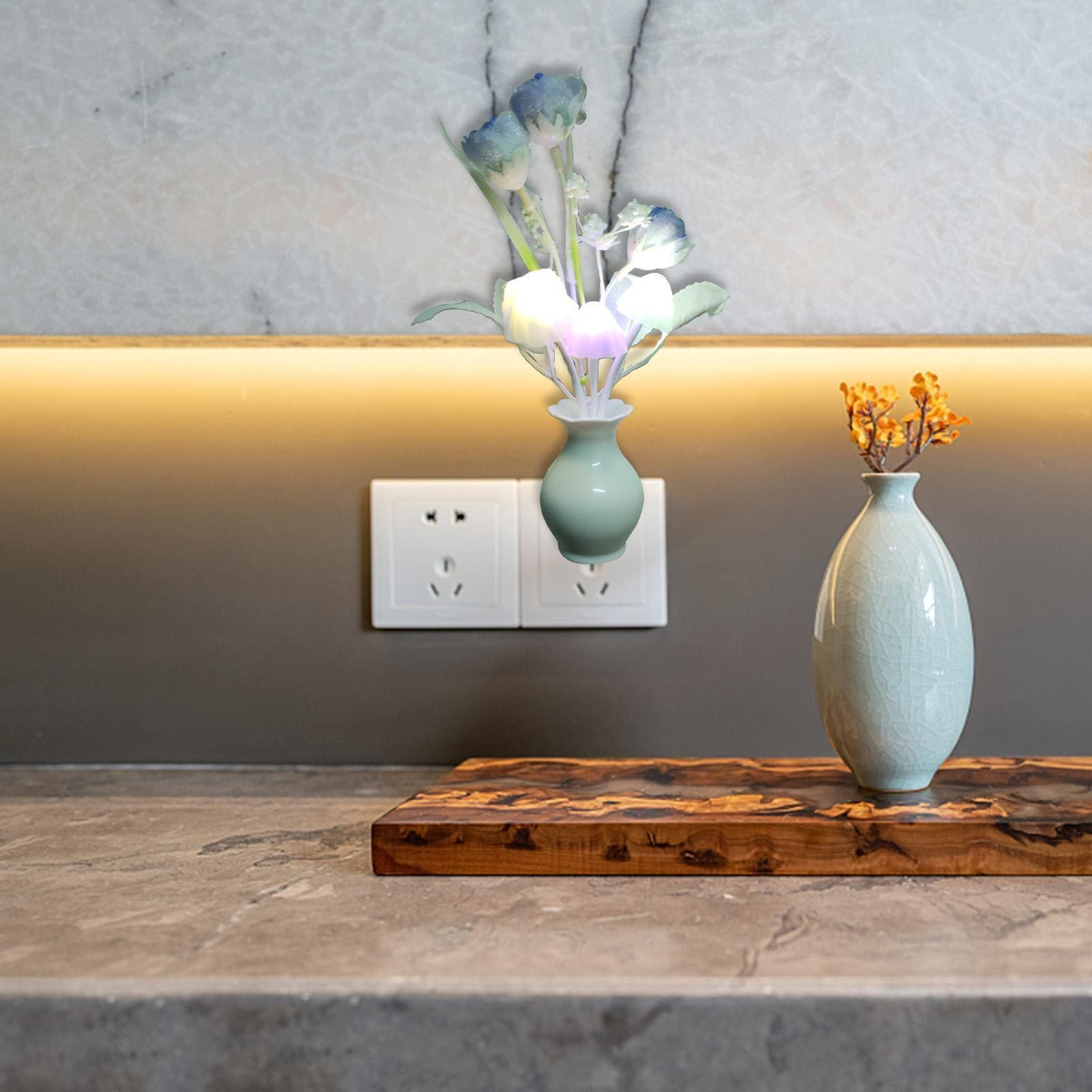 Mini LED night lamp shaped like a white flower plugged into a wall socket above a kitchen counter