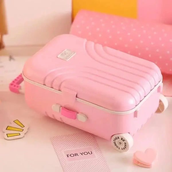 Pink mini musical jewelry box shaped like a small suitcase with handle and decorative items