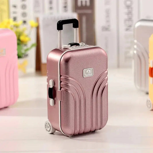 Rose gold mini musical jewelry box shaped like a small suitcase with handle and wheels