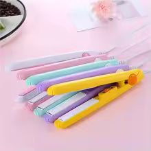 Colorful mini portable hair straightener set on pink surface with compact design for travel