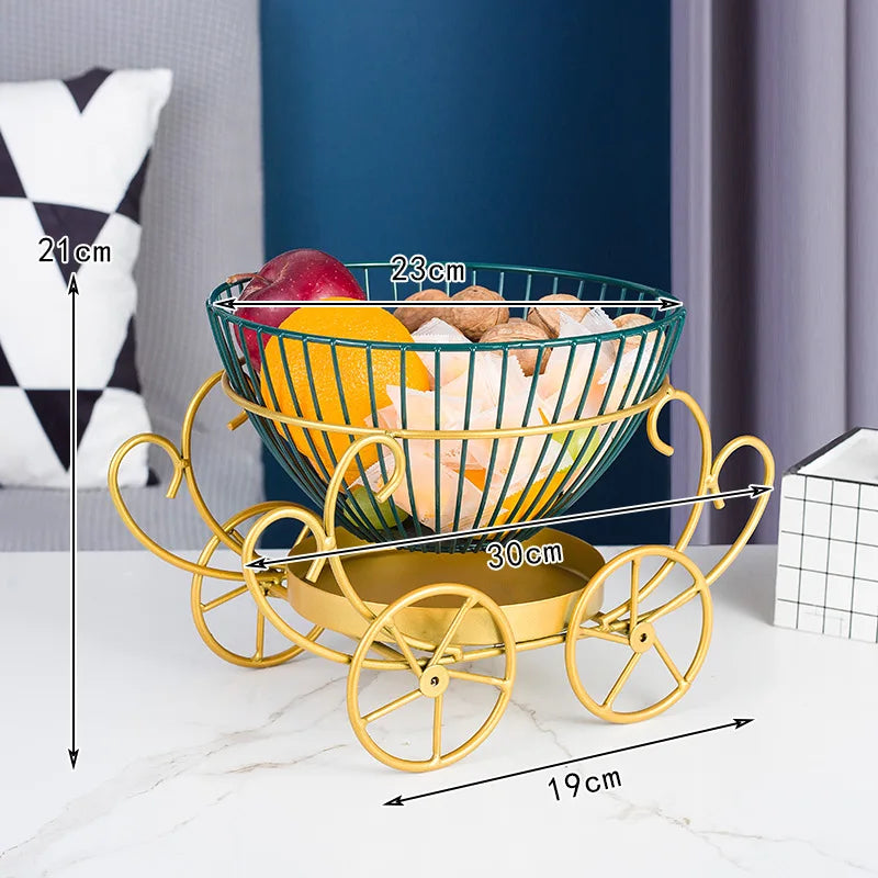Modern fruit basket with gold carriage design holding assorted fruits and nuts on white table