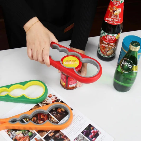 Person using red multi-functional bottle opener to open a jar with additional green and orange openers on table