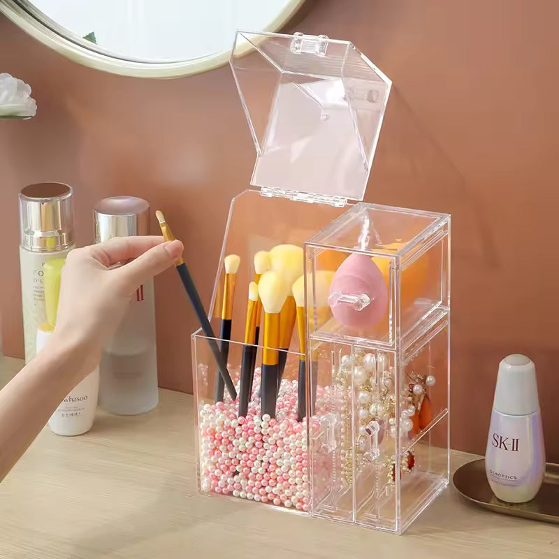Clear multi-functional cosmetic organizer holding makeup brushes, sponge, and jewelry on a vanity table