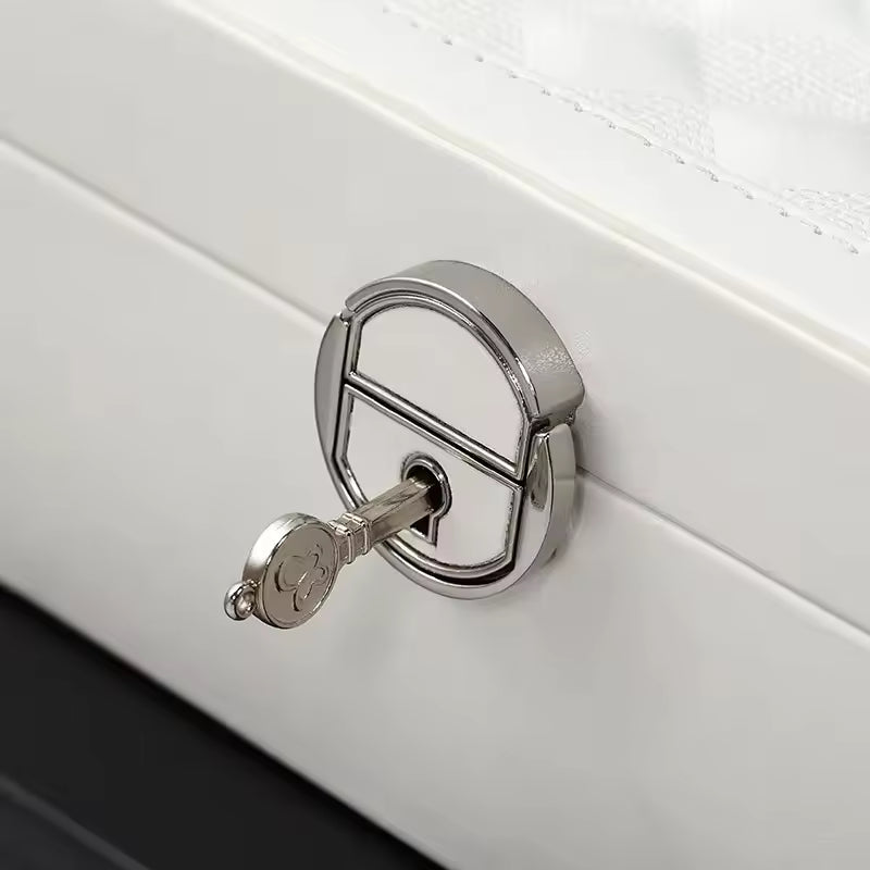 Close-up of silver lock with key on white multi functional leather jewelry box by Clarify.pk