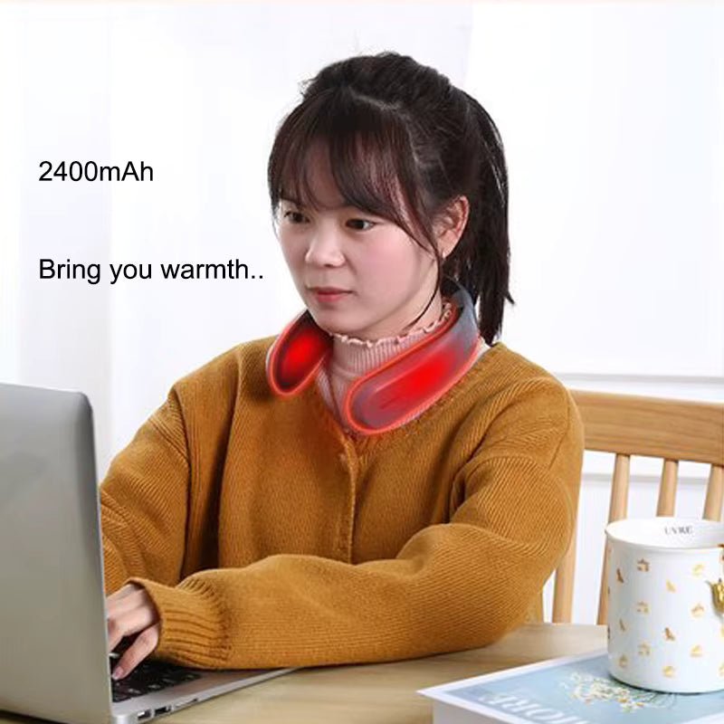Woman using neck ceramic portable heater while working on laptop for warmth and relaxation