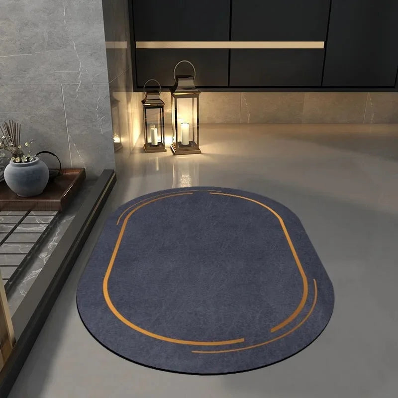 Blue oval non slip bathroom mat with orange accent lines placed on gray bathroom floor