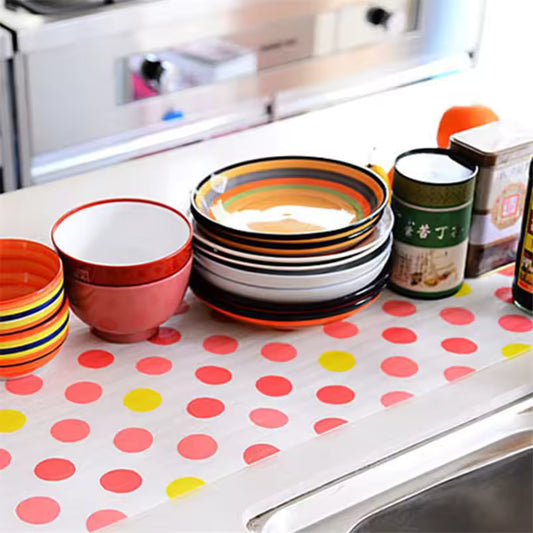 Colorful non-slip cabinet mat for drawers with red and yellow polka dots holding bowls and containers on kitchen counter