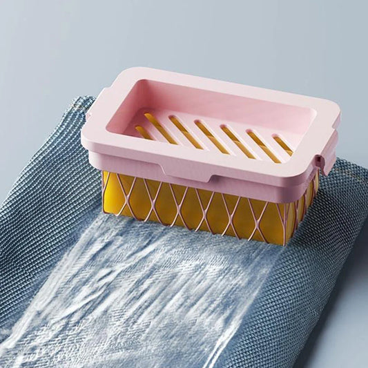 Pink and yellow non slip soap holder draining water over a blue textured cloth