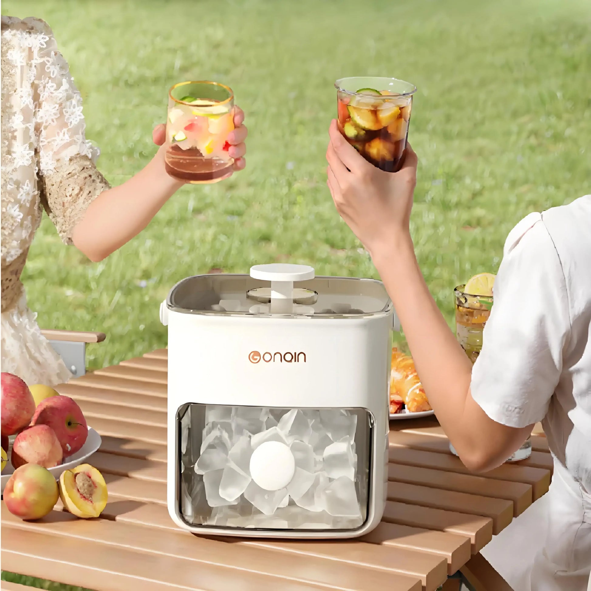 Clarify.pk 48 block ice cube machine with lid on wooden table outdoors with two people holding drinks