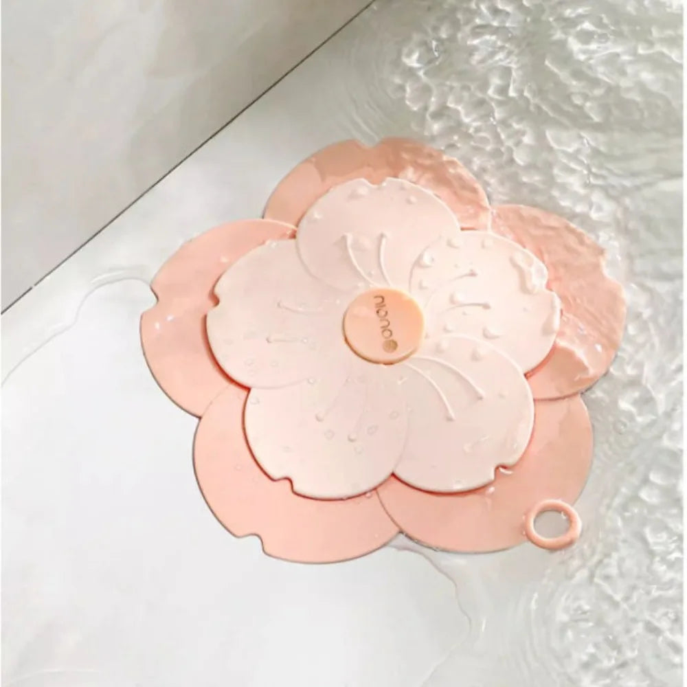 Pink flower-shaped silicone drain cover for bathroom placed over bathtub drain to prevent clogging