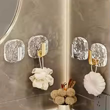 Pack of 4 self adhesive wall hooks with metallic finish holding bath accessories on bathroom wall