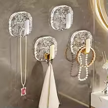 Pack of 4 self adhesive wall hooks holding necklaces and a cloth on a gray wall