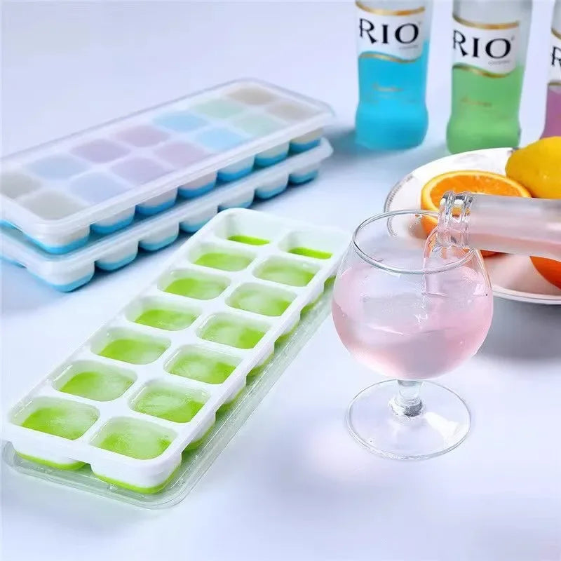 Clarify pk 14 grid silicone ice cube mold with clear lid and green ice cubes next to a glass being filled with pink drink