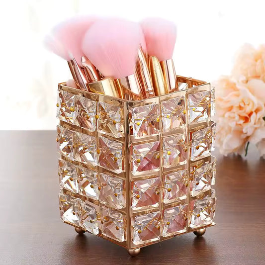 Clarify.pk crystal makeup brush holder with gold frame holding pink makeup brushes on table