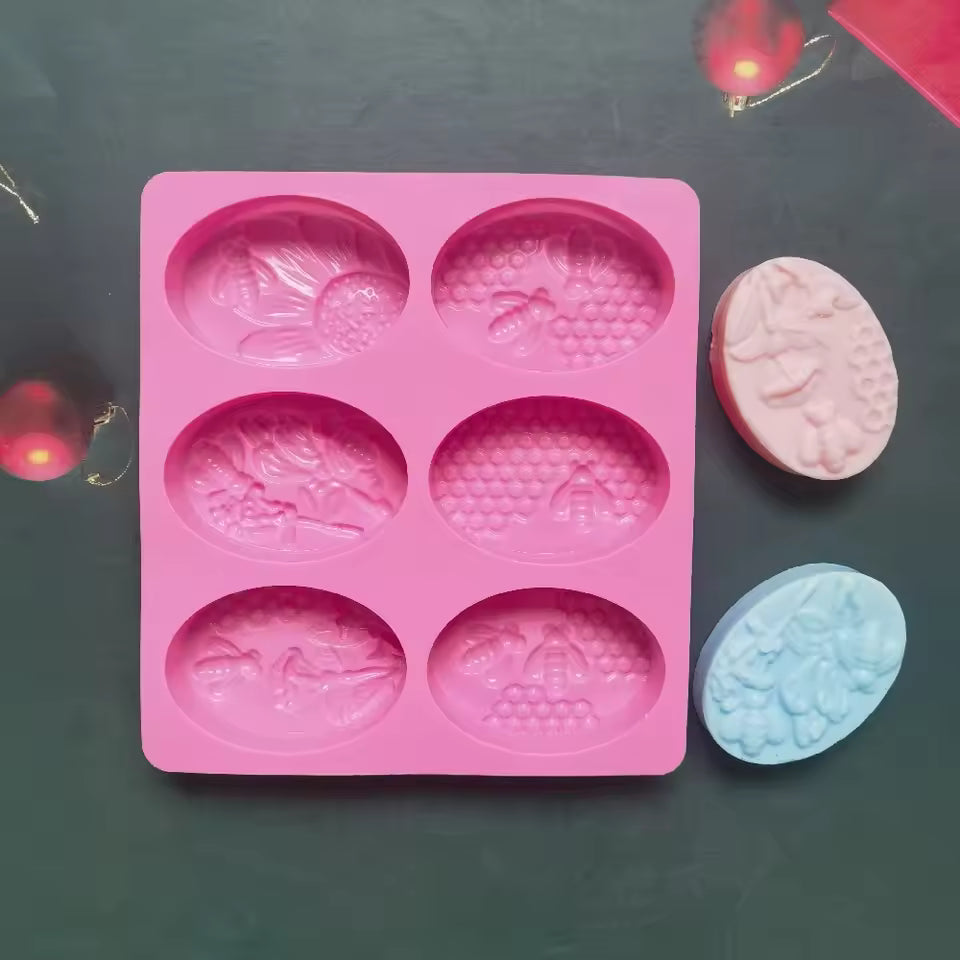 Pink 6 cavity oval soap mold with floral and bee designs for soap making by Clarify.pk
