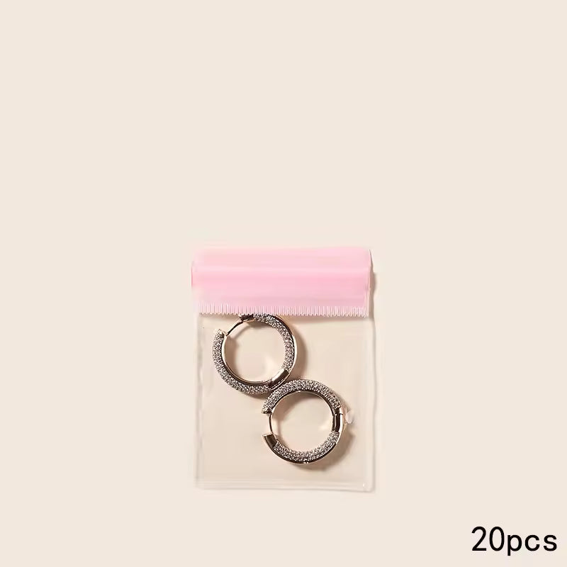 Clear jewelry packaging bag with pink resealable top containing two silver hoop earrings 20pcs