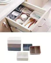 Plastic desktop organizer box with multiple compartments neatly arranged in a drawer for office supplies